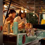 a group of people standing around a food truck
